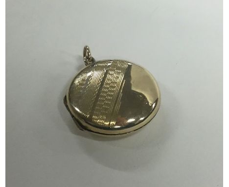 A 9 carat circular back and front locket with engine turned decoration. Approx. 3.3 grams. Est. £30 - £50.
