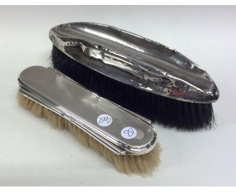 Two silver engine turned hairbrushes. Est. £20 - £30.