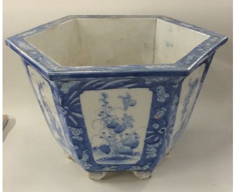 A Chinese blue and white hexagonal planter on pedestal feet decorated with flowers. Approx. 18 cms high. Est. £25 - £35.