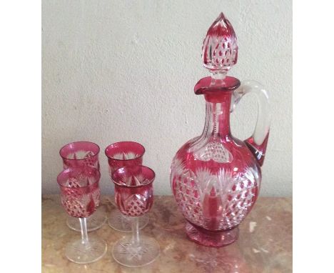 An attractive cranberry glass liqueur set comprising a decanter and four glasses. Est. £30 - £50. 