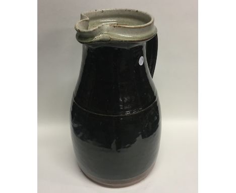 RICHARD BATTERHAM (British: b. 1936): A large 1980s stoneware glazed jug with pouring lip and fluted handle, the exterior in 