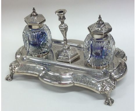 A fine quality Victorian silver inkstand attractively decorated with leaves and flowers on scroll feet with central taper sti