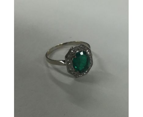 A good emerald and diamond Art Deco style cluster ring in platinum. Approx. 2.2 grams. Est. £1000 - £1500.