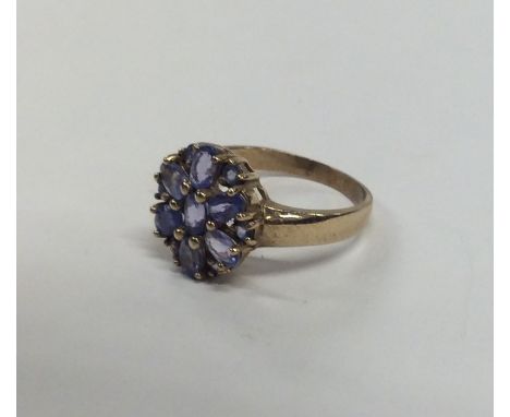 A heavy 9 carat tanzanite cluster ring. Approx. 3.6 grams. Est. £80 - £120.