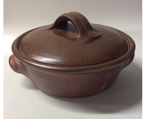 JOHN LEACH (British: b. 1939): A lidded pottery pot with green glazed interior to bowl and lid with handles to side and top. 