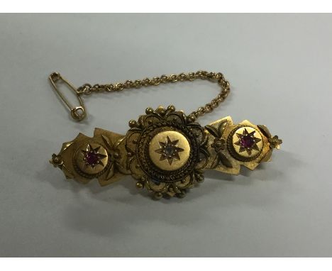 A Victorian 15 carat ruby and diamond brooch. Approx. 4.9 grams. Est. £85 - £95.