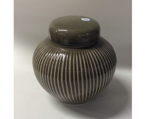 ANDREW CROUCH (British: b. 1955): A small Ludlow contemporary ovoid lidded stoneware tea caddy of fluted design in olive gree