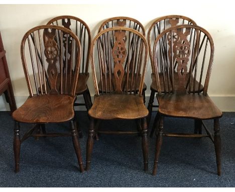 A set of six oak stick back chairs of typical form. Est. £50 - £80.