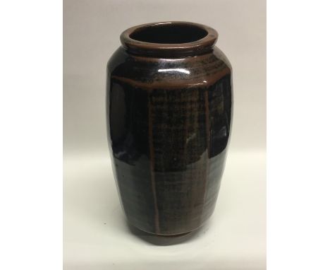 DAVID LEACH (British: 1911 - 2005): A dark brown glazed stoneware pottery vase of tenmoku fluted design. Impressed mark to ba