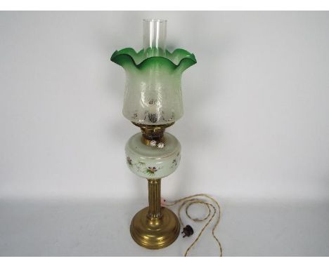 A vintage oil lamp (converted) with hand painted reservoir and green tinted glass shade, approximately 65 cm (h).Condition Re