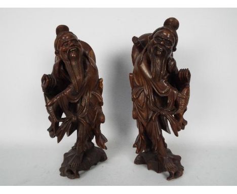 A pair of carved wood figures depicting fishermen, largest approximately 34 cm (h). [2]
