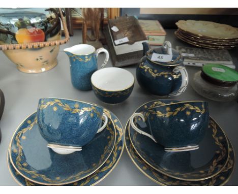 A Royal Worcester tea for two service having gilt heightened garland on blue ground