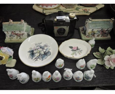 A selection of collectors bells, ceramic cottages, Wedgwood pin dish and Kodak Brownie Cresta camera