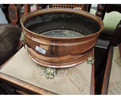 A copper shallow planter having brass lion mask handles