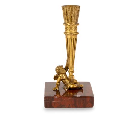 Small gilt bronze candlestick, 19th century chiselled to depict a seated Cupid holding a quiver with arrows; square base in r