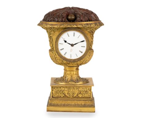 Elegant table clock in gilt bronze, France, early 19th century Vase-shaped case chiselled with foliate and vegetal motifs; ci