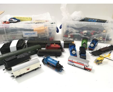 2 plastic containers containing a collection of unboxed HO scale model vehicles , carriages, goods wagons etc together with a