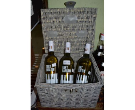 A small painted M&amp;S woven wicker hamper containing three bottles of Gary Barlow white wine (Spanish)