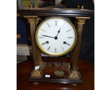 A wooden and gilt metal mantle clock, round face supported on four columns