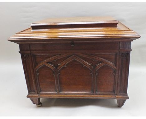 A Victorian oak Gothic Revival cellarette, having cavetto moulded caddy top, the front and sides moulded with Gothic tracery,