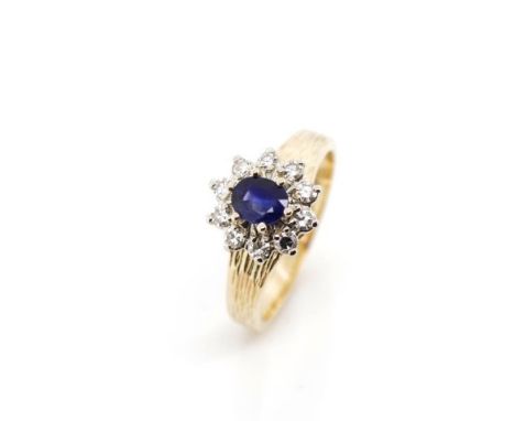 Vintage Sapphire and diamond cluster ring with a white gold setting mounted on a textured rose gold shank. Marked 14k birk. A