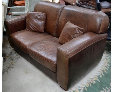 A brown leather two seater sofa