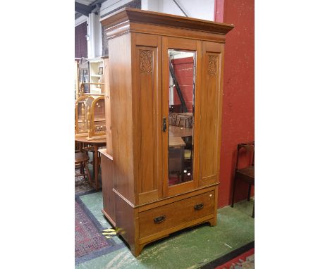 An Edwardian satinwood wardrobe, ogee cornice, mirrored door flanked by carved panels, deep drawer to base, copper Art Nouvea