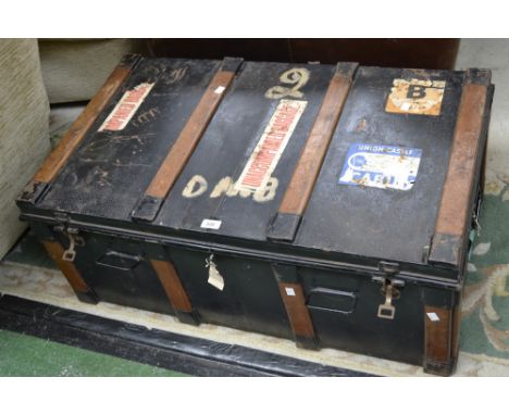 A heavy metal travelling trunk, wooden supports, lacquered interior, carrying handles, some stickers/labels to exterior, lock