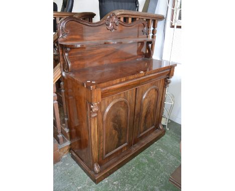 A Victorian mahogany chiffonier, carved gallery, serpentine shelf, S-scroll supports to superstructure. long drawer over two 