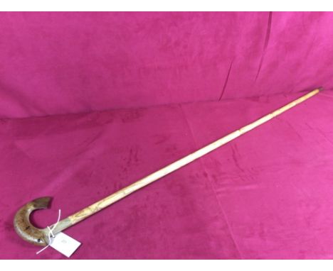 A walking stick with carved horn trout handle