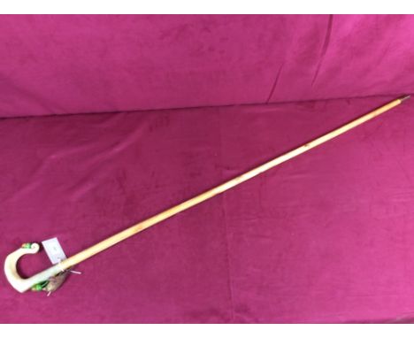 A walking stick, the horn handle decorated with a bird eating an acorn