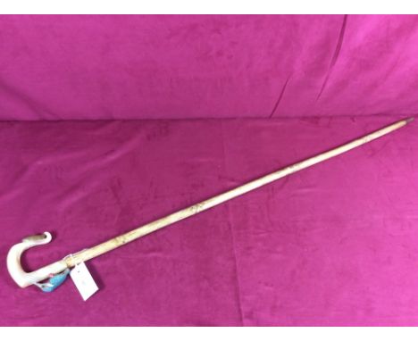 A walking stick, the handle carved with a fish and a kingfisher