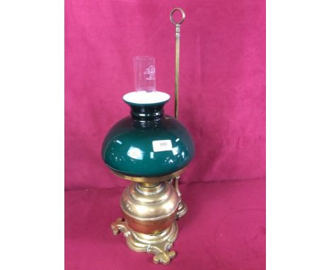 An antique brass adjustable oil lamp with green glass shade