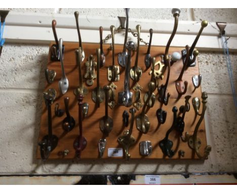 A collection of various hat and coat hooks on a display board - some vintage