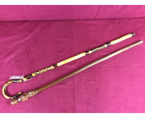 A walking stick with ethnic style decoration; and another example, the handle carved with an ethnic tribeswoman