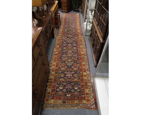 An old Persian runner, blue ground with geometric design.