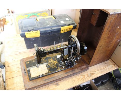 A Frister and Rossmann sewing machine and a box of tools.