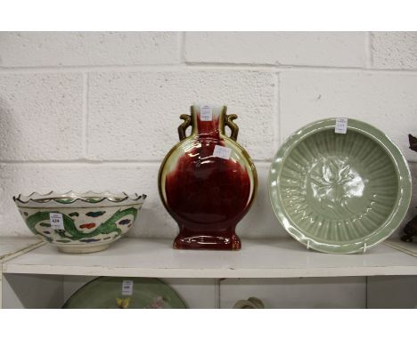 A Chinese bowl decorated with a dragon, a moon flask and a celadon dish.