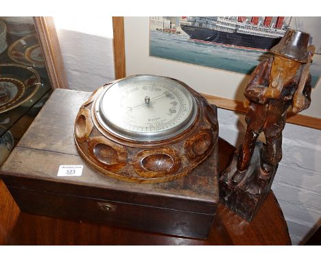 Carved oak aneroid barometer, a Victorian writing slope and a carved wood figure of an axeman 