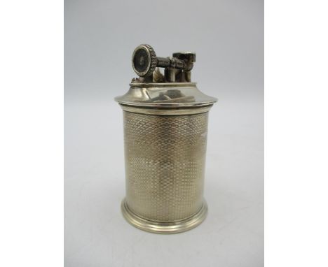 A George V silver table lighter by The Goldsmith and Silversmith Company Ltd, with cylindrical engine turned body, 9 cm high 