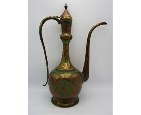 A large Persian kahmiri enamelled brass ewer, extensively decorated with red ground enamel and relief foliage throughout, wit