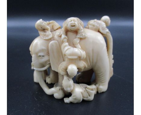 A Japanese Meiji period ivory netsuke, modelled as six blind men and an elephant, as an allegory of truth and interpretation,