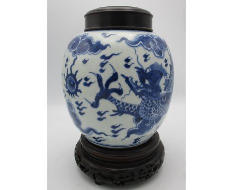 A Chinese Kangxi blue and white porcelain ginger jar, with dragon and pearl design, turned wooden lid and carved pierced wood