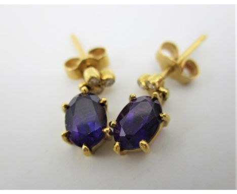 A pair of 18ct gold earrings, each set with three diamonds and an amethyst pendant, 2.3g in a Garrards &amp; Co Ltd box 