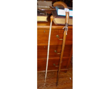 A Victorian sword stick disguised as a wooden walking stick together with a walking cane made from snake vertebrae