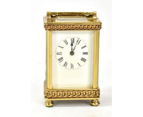 A brass cased carriage clock, the circular dial set with Roman numerals, raised on four feet, height excluding swing handle 1