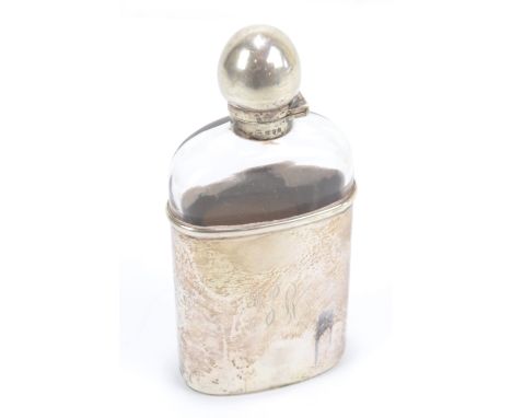 GOLDSMITHS &amp; SILVERSMITHS CO LTD; a hip flask, the clear glass body with silver cup and stopper, engraved with initials, 