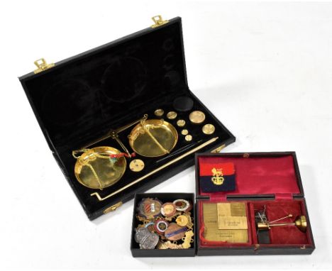 A cased set of scales and weights, a cased Casartelli &amp; Son yarn sorting balance and a small group of badges including ha