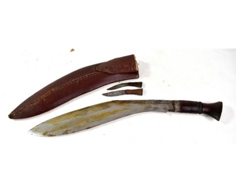 A mid-20th century kukri with engraved detail to lower section of blade, blade length approx 36.5cm, with wooden grip and bra