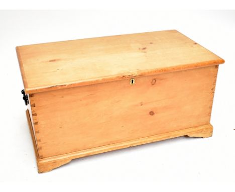 A pine rectangular blanket box, the hinged cover lifts to enclose a candle box and single drawer, raised on bracket supports,